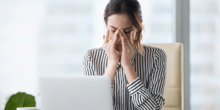Woman with sore eyes at laptop monitor